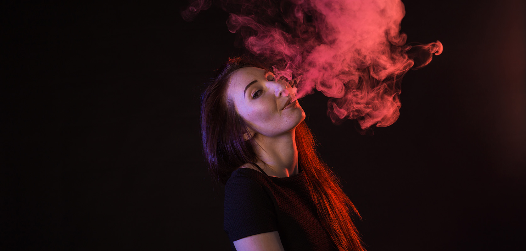 adult woman blowing vape smoke cloud. buy thc concentrates online canada.
