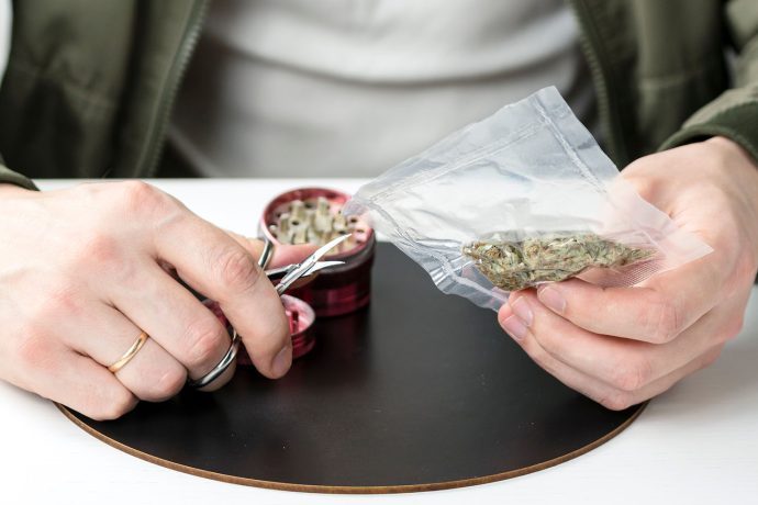 man rolling a joint after buying weed online. order weed online in canada from west coast cannabis online dispensary.