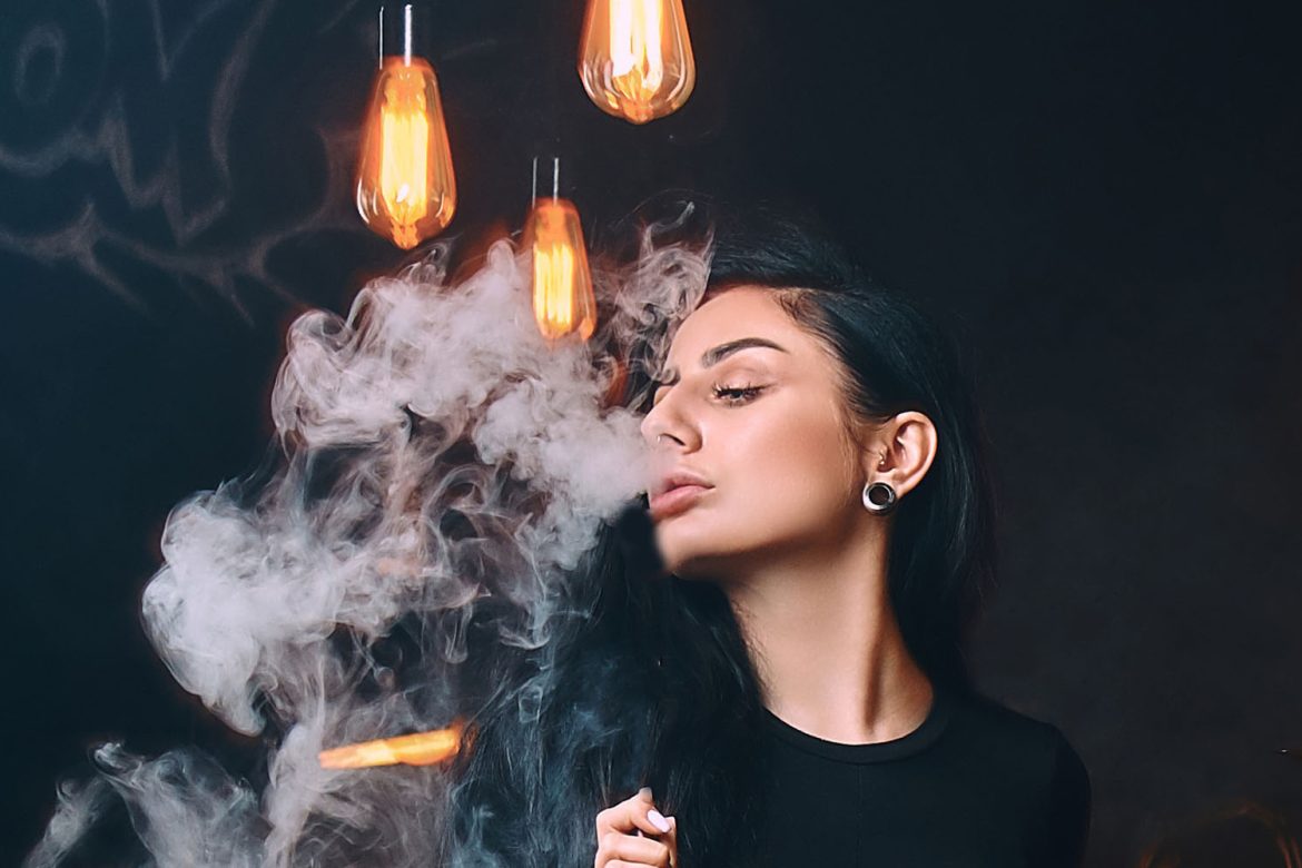 adult lady blowing smoke clouds after using a dab rig. buy weed online canada.