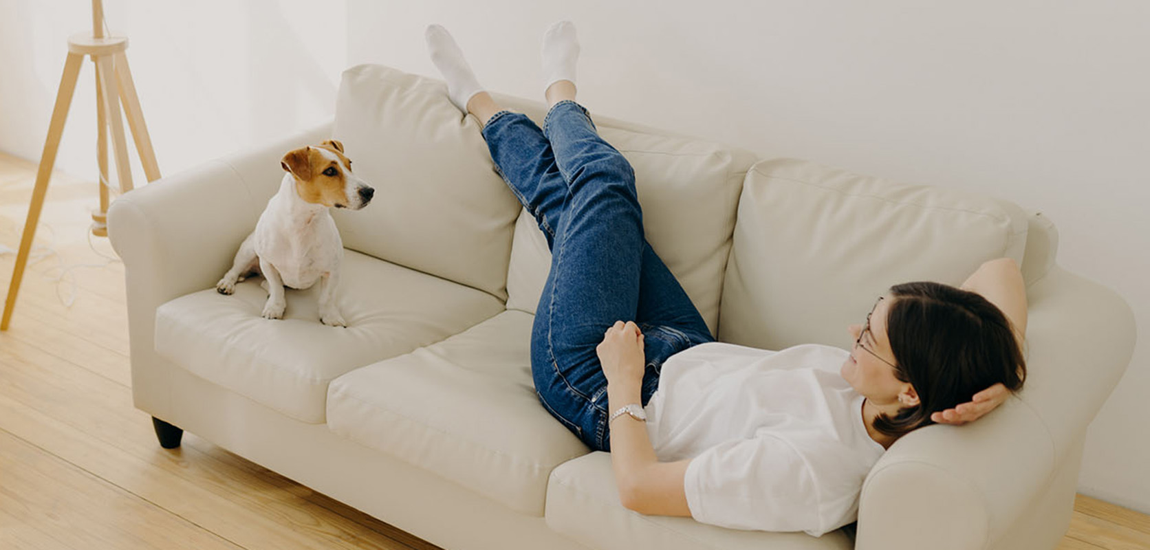 Woman relaxing with her dog on sofa at home after buying weed online in Canada.