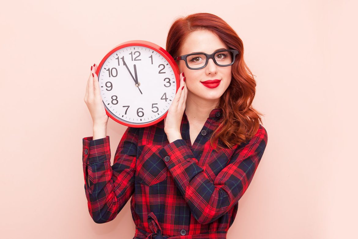 Redhead holding a clock. How long does weed stay in your system.