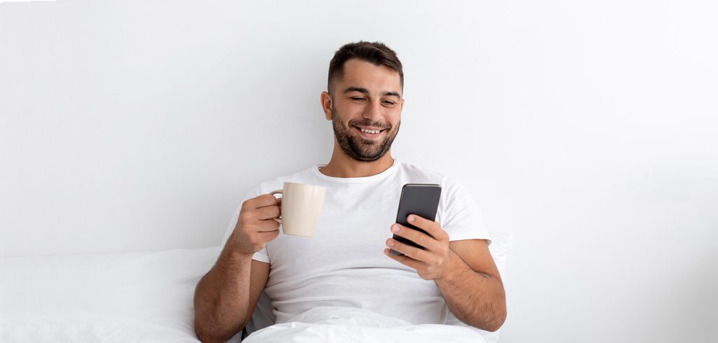 cheerful young muscular caucasian male using a phone