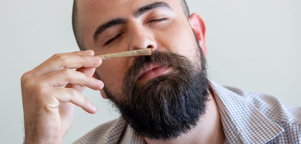 man smelling a joint. bc cannabis stores. weed vape. sativa strains. weed canada. Dispencary. weed shop. budmail. 