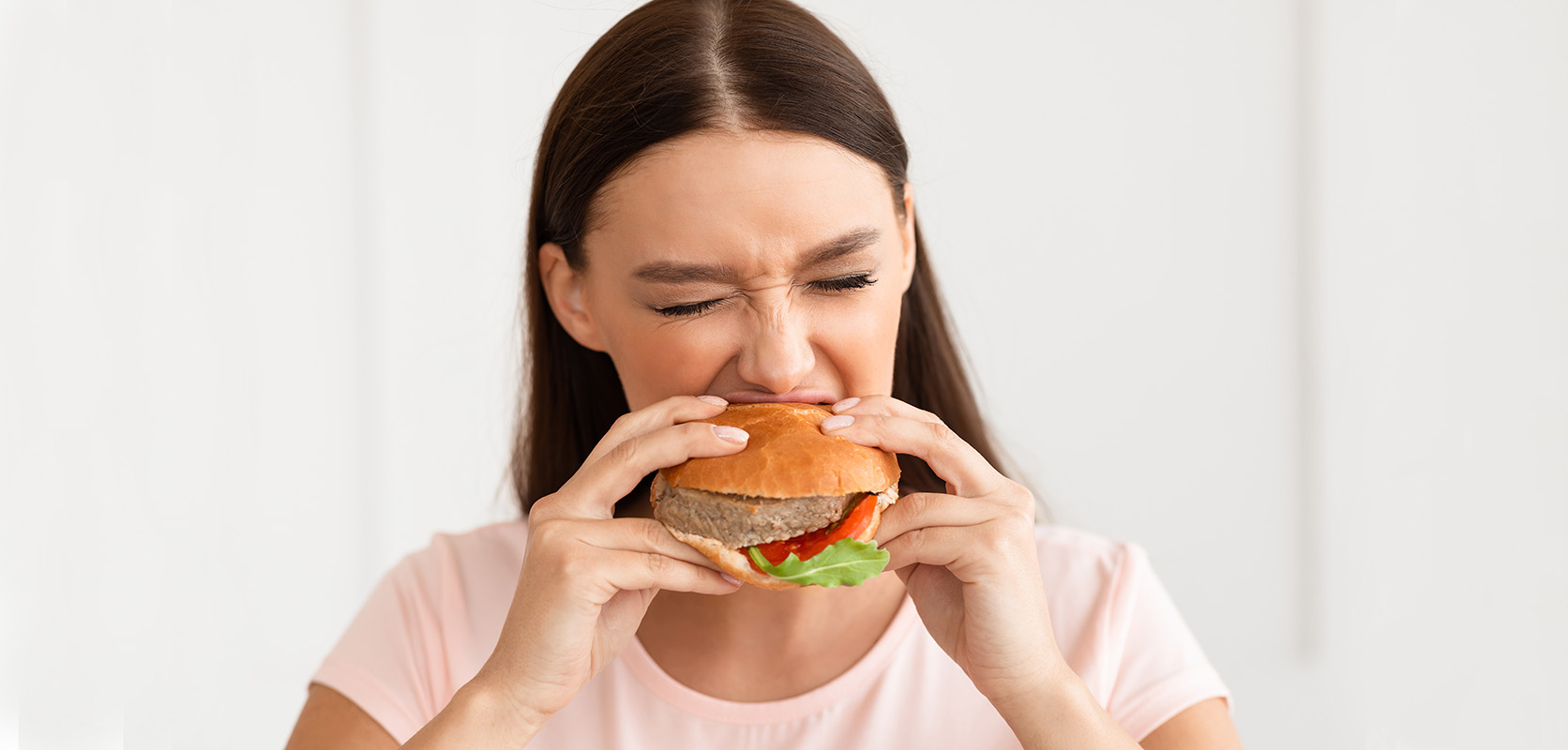 Woman enjoying a burger after buying hash online from west coast cannabis dispensary and mail order weed online Canada. BC cannabis. budgetbuds.