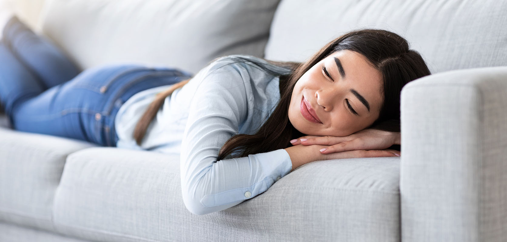 Happy woman sleeping on sofa at home feeling the effects of the OG Kush strain. online dispensary canada to buy weeds online. cannabis canada. Dispencary.